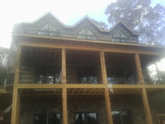 Dormers and porch framing on a large log home under construction — Roof Coating work by our crew in Pennsylvania Furnace
