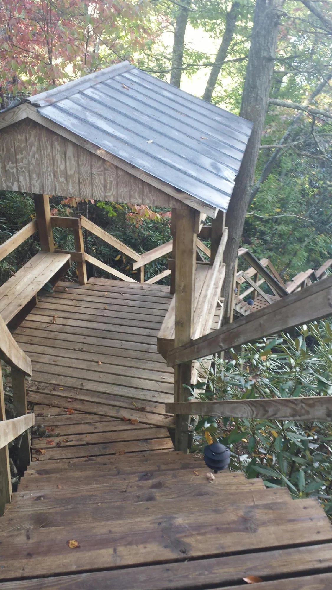 Metal roofed shelter over wooden steps on a wooded walkway — Skylight Repair & Installation work by our crew in Pennsylvania Furnace